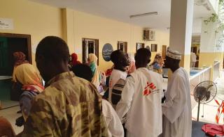 People gather at a health facility in El Fasher