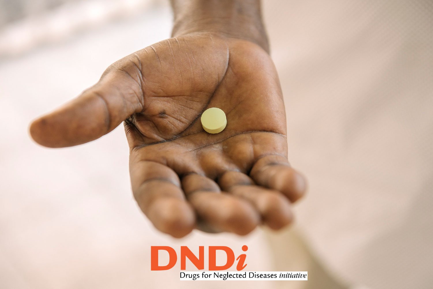 DNDi logo with pill in hand